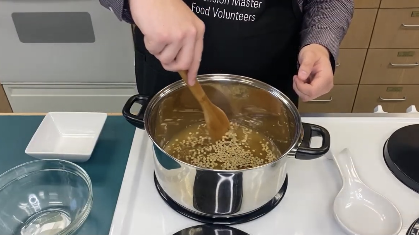 Person cooking lentils in a pot