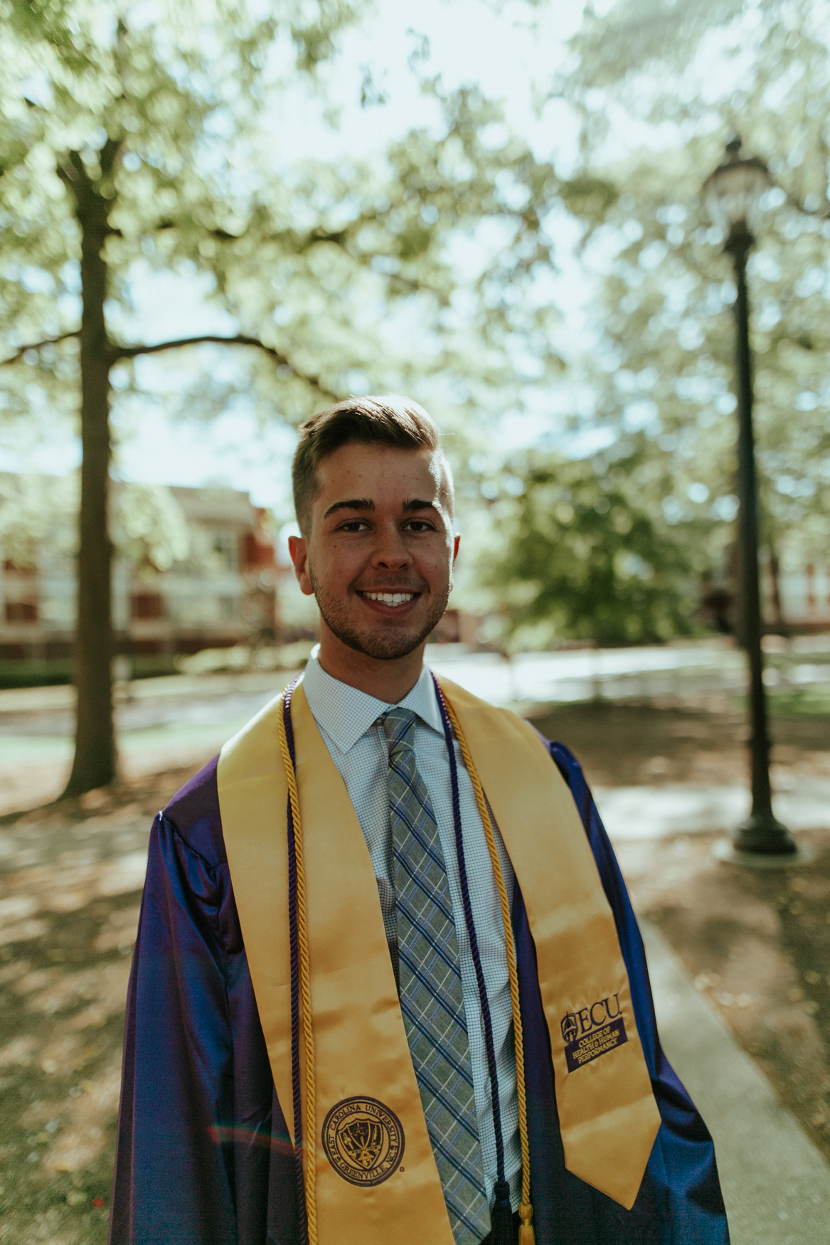 Kenan pictured in graduation regalia from East Carolina University