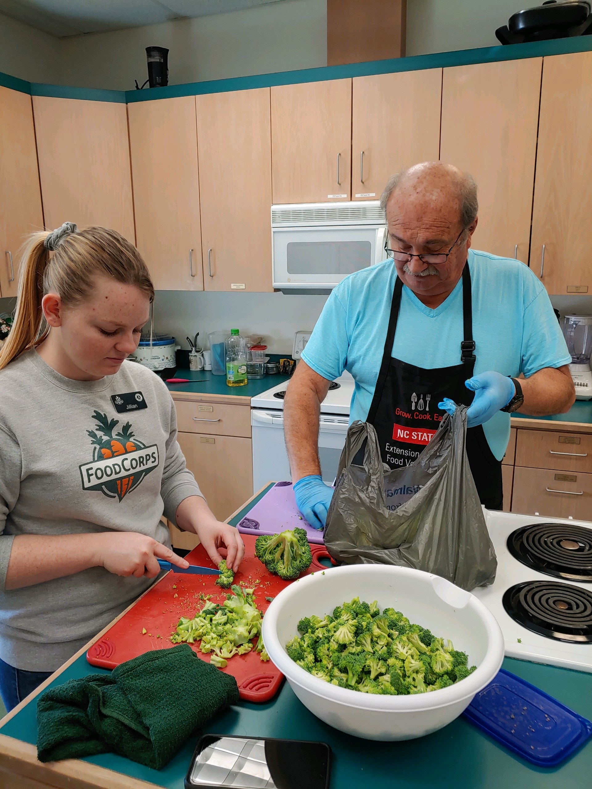 food corps service member and extension master food volunteer preparing broccoli 