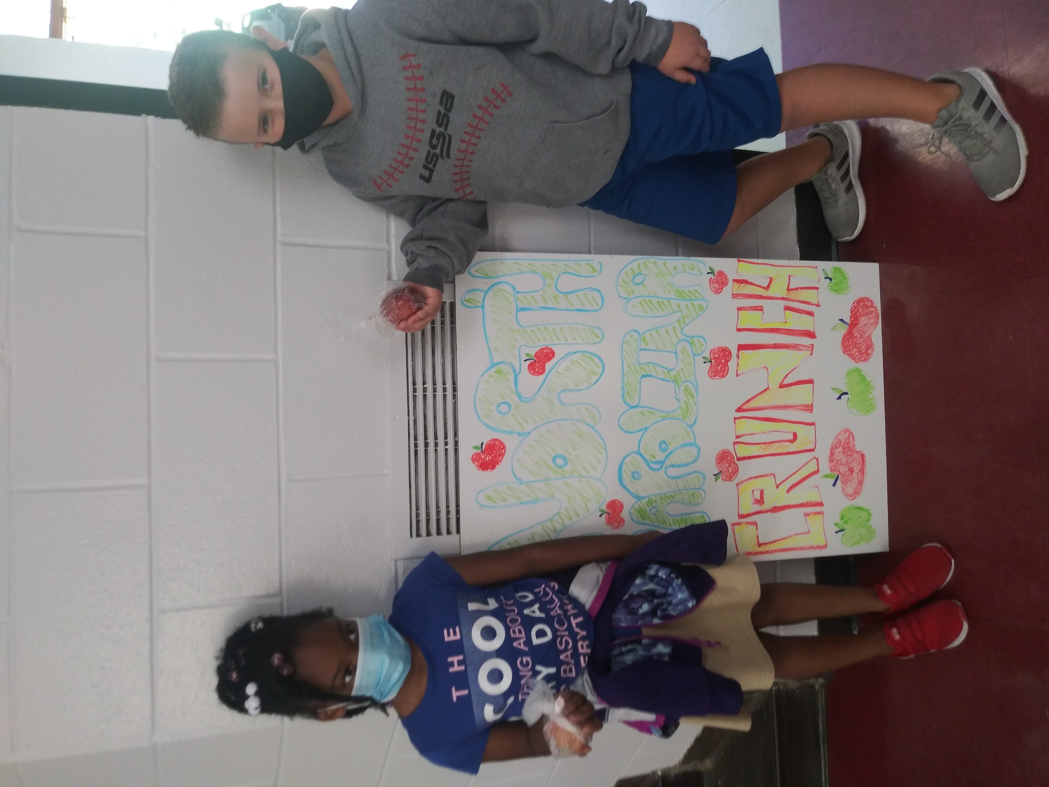two students holding apples with "North Carolina Crunch" Sign