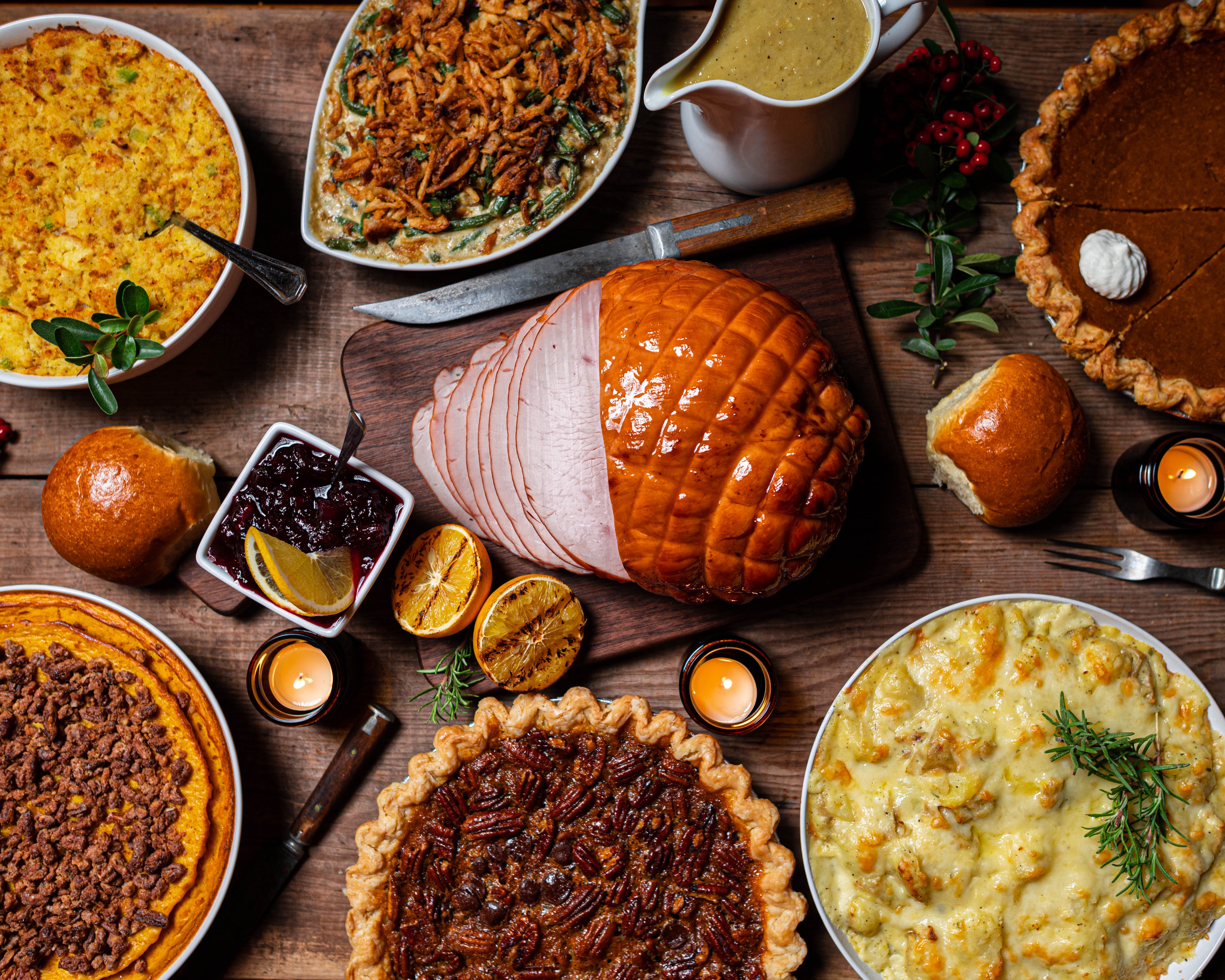 Display of traditional thanksgiving foods including pecan pie, ham, and stuffing
