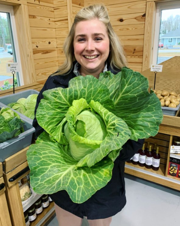 girl smiling and holding cabbage