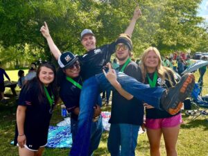4-H youth lift their coach into the air in celebration