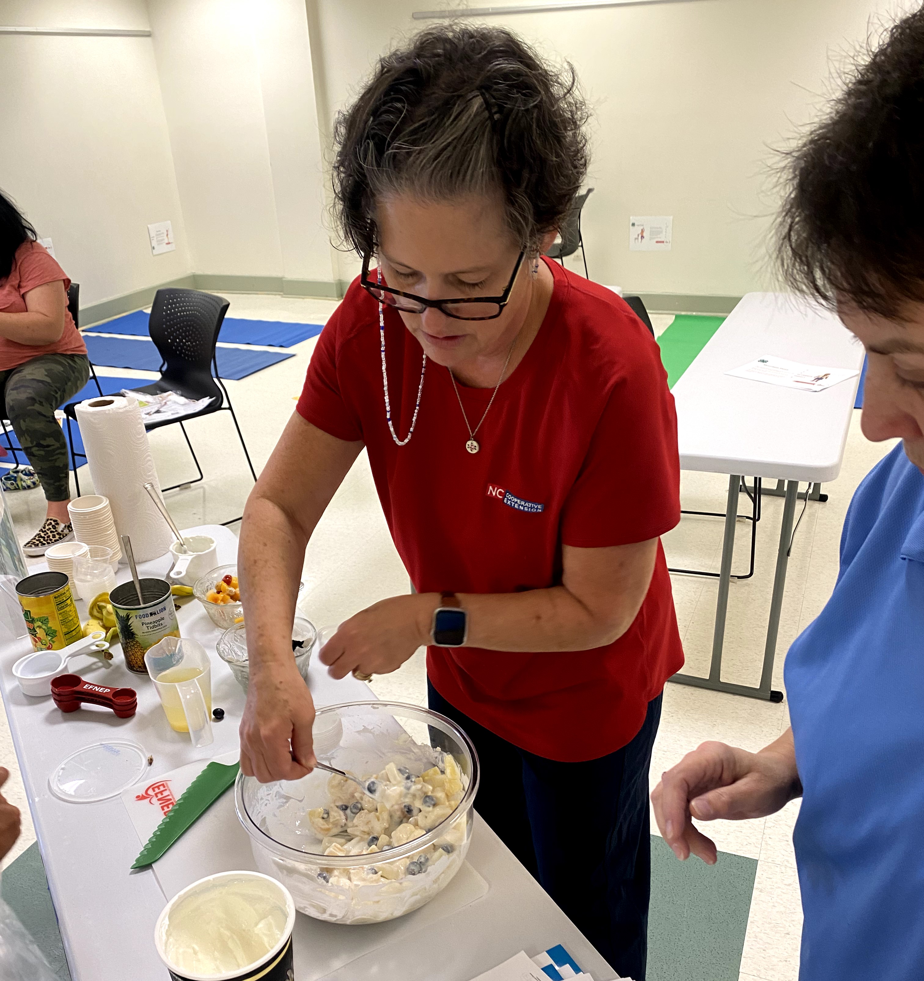 staff and participant stirring food for cooking activity