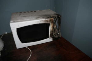 broken damaged and burned microwave caused by an electrical failure
