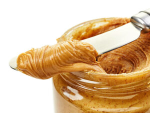 peanut butter spread on a knife and jar