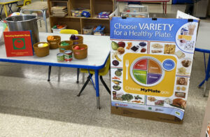 the book "Growing Vegetable Soup" set up with fake vegetables on table for kids.
