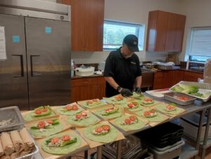 Chef JOhn Latour preparing chicken salad wraps for the boxed meal for the Care Fair participants