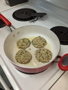  Extension Master Food Volunteer Terry Amrhein from Sunset Beach preparing the salmon burgers in the Extension Demonstration kitchen.