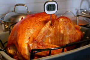 roasted turkey with a food thermometer sticking out of it.