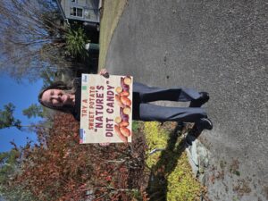 Extension CED Amy Mead holding a sweet potato sign