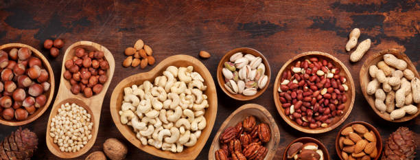 Various nuts selection: peanuts, hazelnuts, chestnuts, walnuts, pistachio and pecans on wooden table. Top view flat lay