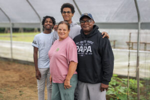 Timmy Taylor standing with his wife and grandkids